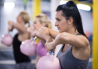 Image showing athletes doing exercises with kettlebells