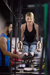 Image showing woman working out with personal trainer on gymnastic rings