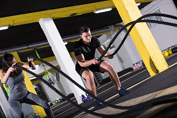 Image showing sports couple doing battle ropes cross fitness exercise