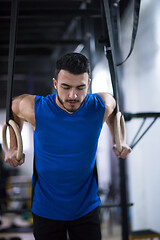 Image showing man working out pull ups with gymnastic rings