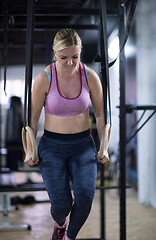 Image showing woman working out pull ups with gymnastic rings