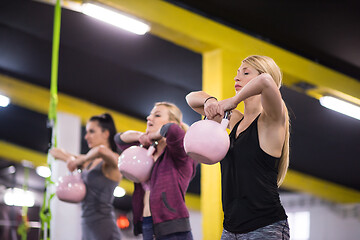 Image showing athletes doing exercises with kettlebells