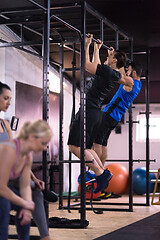 Image showing young athletes doing pull ups on the horizontal bar