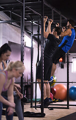 Image showing young athletes doing pull ups on the horizontal bar