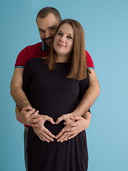 Image showing pregnant couple  isolated over blue background