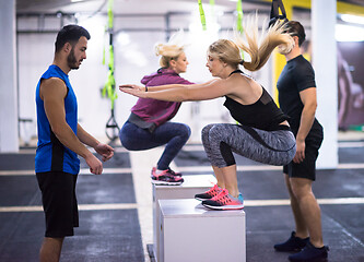 Image showing athletes working out  jumping on fit box