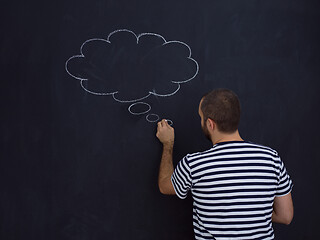 Image showing young future father thinking in front of black chalkboard