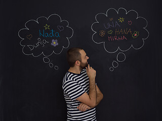 Image showing young future father thinking in front of black chalkboard