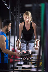 Image showing woman working out with personal trainer on gymnastic rings