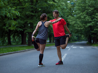 Image showing runners team warming up and stretching before morning training