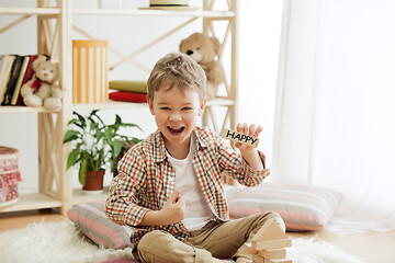 Image showing Wooden cubes with word HAPPY in hands of little boy