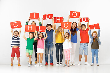 Image showing Childhood. Group of children with a red banners isolated in white