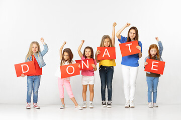 Image showing Donate. Group of children with red banners isolated in white