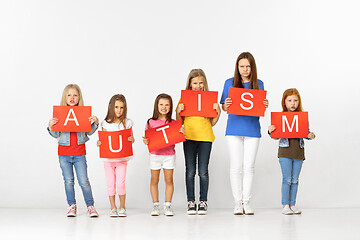 Image showing Autism. Group of children with red banners isolated in white