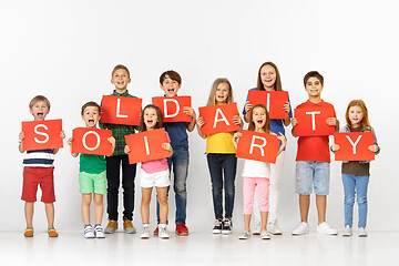 Image showing Solidarity. Group of children with a red banners isolated in white