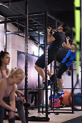 Image showing young athletes doing pull ups on the horizontal bar