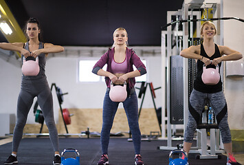 Image showing athletes doing exercises with kettlebells