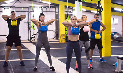 Image showing athletes doing exercises with kettlebells