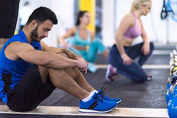 Image showing young athletes doing pushups with kettlebells