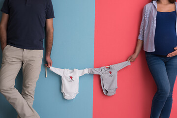 Image showing young couple holding baby bodysuits