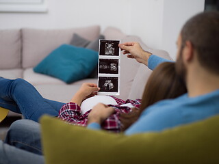 Image showing pregnant couple looking baby\'s ultrasound