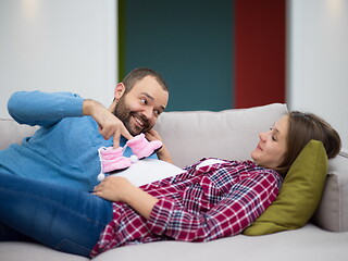 Image showing young pregnant couple relaxing on sofa