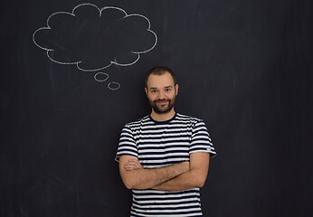 Image showing young future father thinking in front of black chalkboard