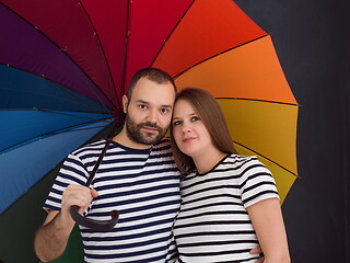 Image showing pregnant couple posing with colorful umbrella