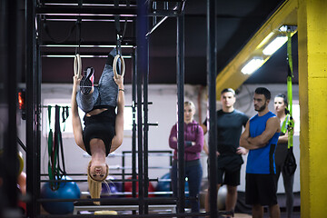 Image showing woman working out with personal trainer on gymnastic rings