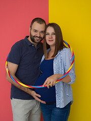 Image showing pregnant couple  isolated over colorful background