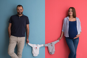 Image showing young couple holding baby bodysuits