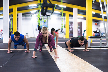 Image showing young healthy people doing pushups