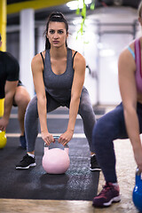 Image showing athletes doing exercises with kettlebells