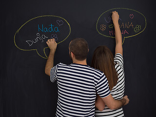 Image showing pregnant couple writing on a black chalkboard