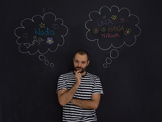 Image showing young future father thinking in front of black chalkboard