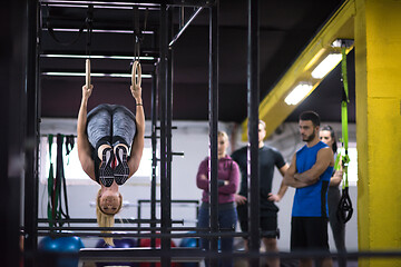 Image showing woman working out with personal trainer on gymnastic rings