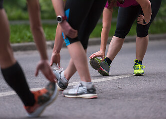 Image showing runners team warming up and stretching before morning training