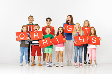 Image showing Our rights. Group of children with red banners isolated in white