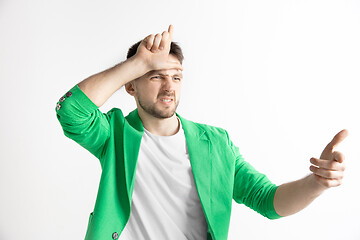 Image showing Losers go home. Portrait of happy guy showing loser sign over forehead