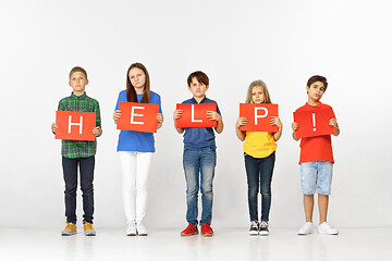 Image showing Help. Group of children with red banners isolated in white