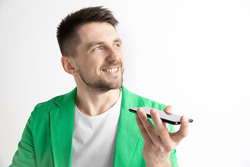 Image showing Indoor portrait of attractive young man holding smartphone