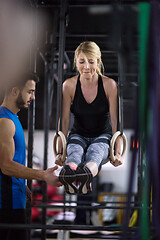 Image showing woman working out with personal trainer on gymnastic rings