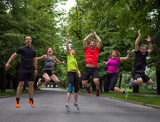 Image showing runners team jumping in the air during  morning training