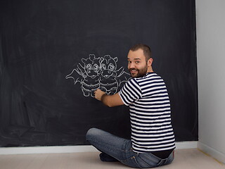 Image showing future dad drawing his imaginations on chalk board