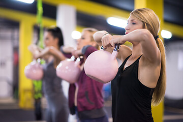 Image showing athletes doing exercises with kettlebells