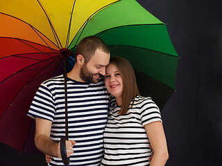 Image showing pregnant couple posing with colorful umbrella