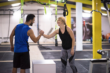 Image showing woman working out with personal trainer jumping on fit box