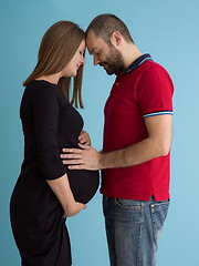 Image showing pregnant couple  isolated over blue background