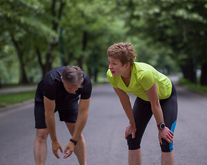 Image showing runners team warming up and stretching before morning training