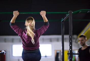 Image showing woman doing pull ups on the horizontal bar